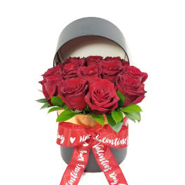 Red roses in a black hatbox with a red Valentine ribbon