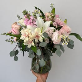 Pink and white mixed flower arrangement in a glass vase