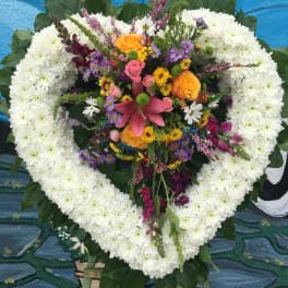Heart-shaped floral wreath with white chrysanthemums and a colorful center bouquet