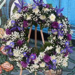 Purple and white floral wreath on a wooden easel