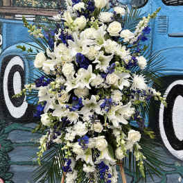 Tall white and blue floral standing spray on an easel