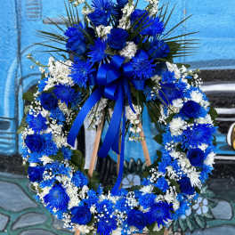 Blue and white floral wreath on a wooden easel with a ribbon bow