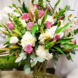 Large bouquet of pink and white flowers in a glass vase