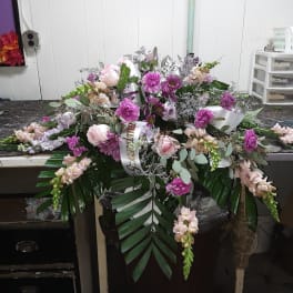 Large pink and lavender floral spray with ribbon and greenery