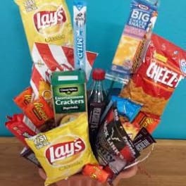 Snack bouquet in a pink vase with assorted chips and candy bars