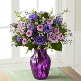 Purple and pink mixed bouquet in a purple glass vase