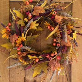 Autumn wreath with berries and mixed foliage on a wooden door