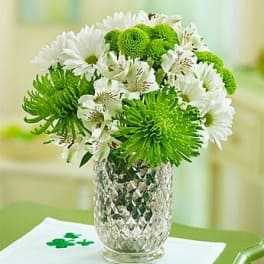 White and green bouquet in a clear textured vase