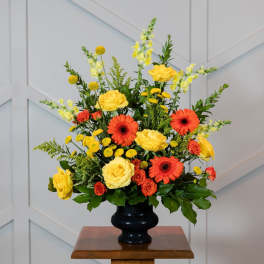 Yellow and orange floral arrangement in a black vase
