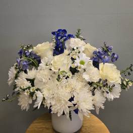White and blue flower arrangement in a white vase
