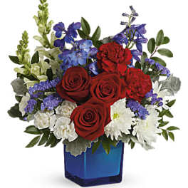 Red roses and mixed blue-white flowers in a blue glass vase