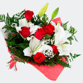 Bouquet of red roses and white lilies wrapped in pink paper