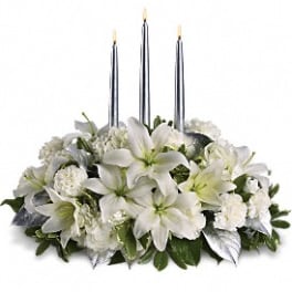 White floral centerpiece with three tall candles