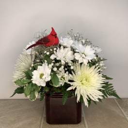 White daisy bouquet in a dark vase with a red cardinal decoration