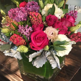 Bouquet of pink and white flowers in a square glass vase