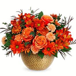 Orange roses and daisies in a gold textured vase