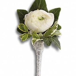 White flower boutonniere with green leaves and silver-wrapped stem