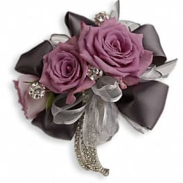 Purple rose corsage with silver ribbon and rhinestone accents