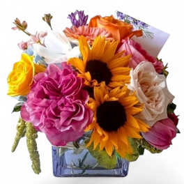 Mixed bouquet of roses and sunflowers in a blue glass vase