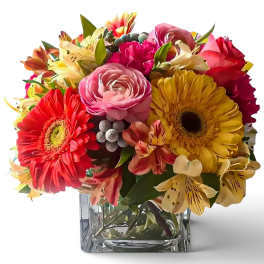 Colorful mixed bouquet in a clear square glass vase