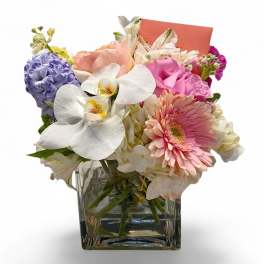 Mixed pastel bouquet in a clear square glass vase