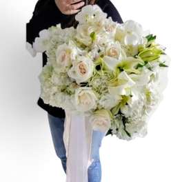 Large white bouquet with roses and lilies, tied with a long ribbon