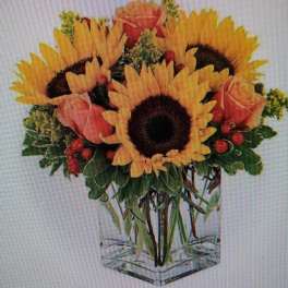 Sunflower bouquet with pink roses in a clear square vase