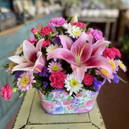 Pink lilies and mixed daisies in a floral gift box
