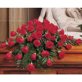 Casket spray of red roses on a wooden casket