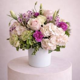 Pink and cream floral arrangement in a white vase
