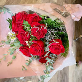 Bouquet of red roses wrapped in pink paper