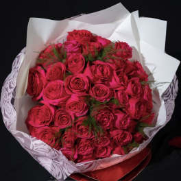 Bouquet of bright pink roses wrapped in white paper