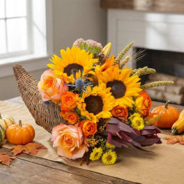 Autumn bouquet with sunflowers and peach roses in a woven basket
