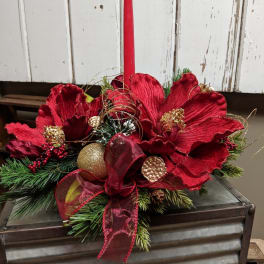 Red floral centerpiece with a tall candle in a metal container