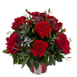 Red roses and carnations arranged in a red vase