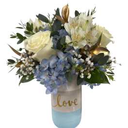 White roses and blue hydrangeas in a blue vase with "love" text