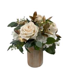 Cream roses in a wooden vase with green foliage