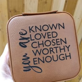 Tan square gift box with the words "known loved chosen worthy enough"
