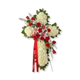 Standing floral spray with red roses, white lilies, and white blooms on a ribboned cross