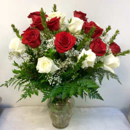 Red and white roses arranged in a clear glass vase