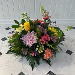 Low mixed bouquet with roses, chrysanthemums, and carnations in pink, yellow, and lavender