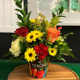 Colorful mixed flower arrangement in a teacher-themed pot