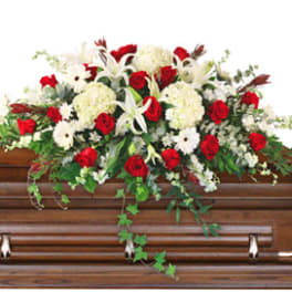 Red and white floral spray on a wooden casket