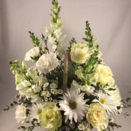 White and pale yellow flowers in a wicker basket arrangement