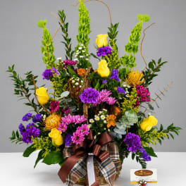 Basket arrangement with yellow roses, purple and pink blooms, and tall green accents