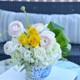 Bouquet of white, pink, and yellow flowers in a blue-and-white vase