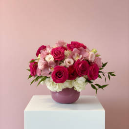 Pink and white rose bouquet in a purple vase