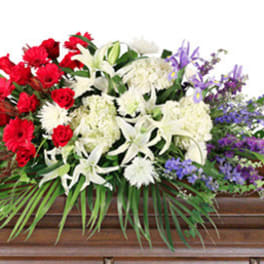 Red, white, and purple floral spray on a casket