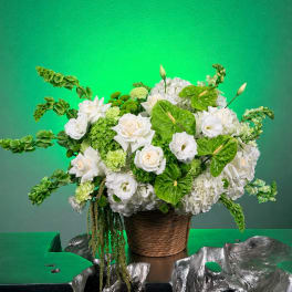White and green floral arrangement in a woven basket