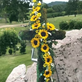 Sunflower garland draped over a large cross outdoors